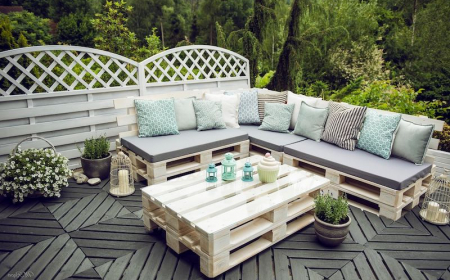salon de jardin avec des palettes style scandinavien avec table basse et canape en boir rempli de ocussin beige