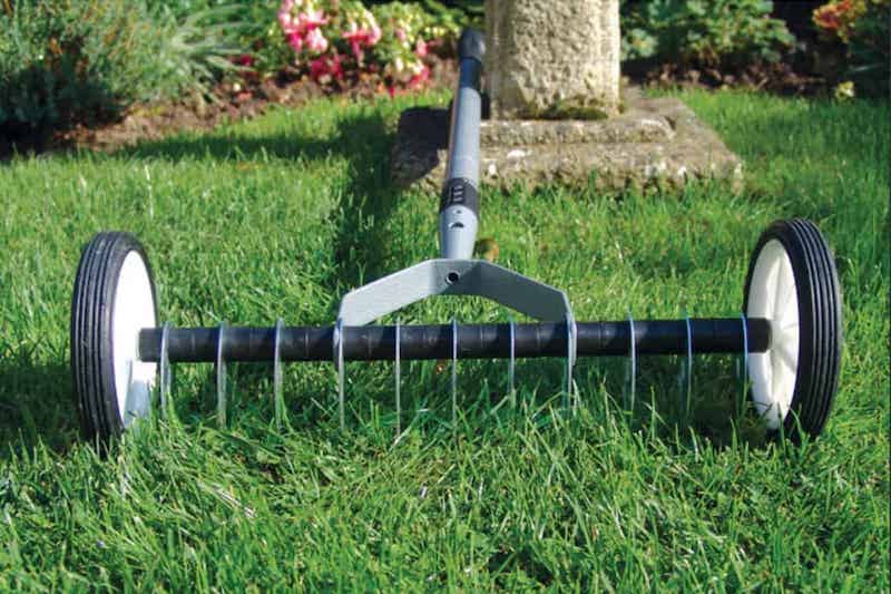 scarification de la pelouse en prevention du janissement un outil sur une pelouse verte
