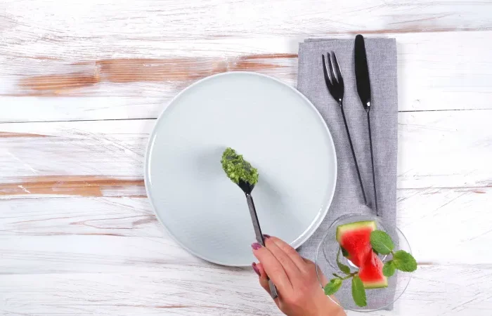 badigeonner une assiette de pesto roquette pour composer salade d été