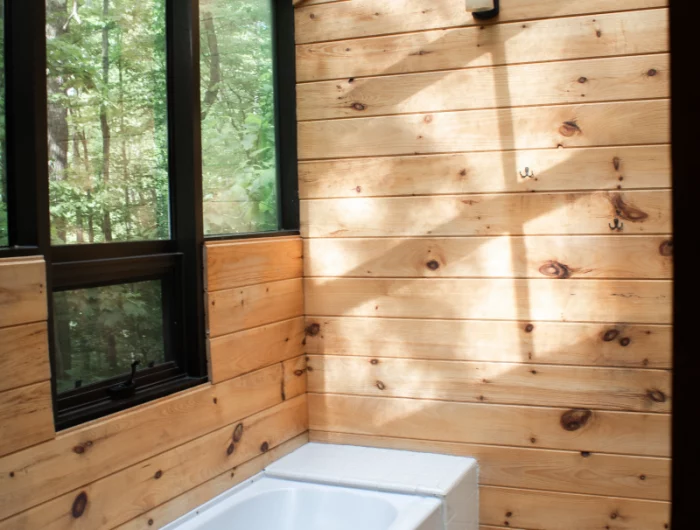 baignoire carrelage blanc murs en bois fenetre cadre noir mat