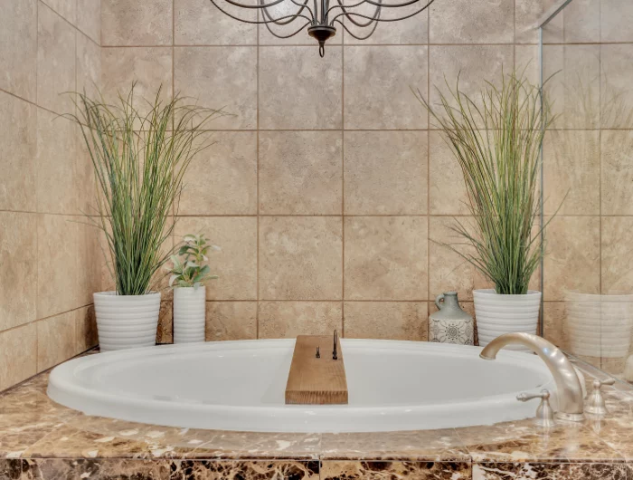 carrelage beige baignoire plantes vertes eclairage deco salle de bain