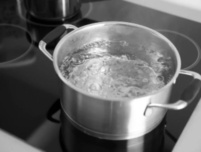 de l'eau qui bouille dans une casserole sur une plaque electrique pour blanchire des chaussettes