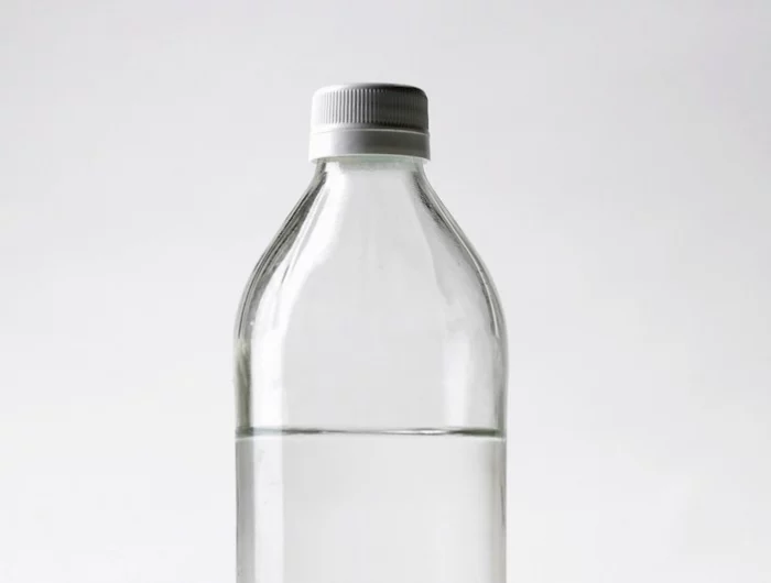du vinaigre pour un nettoyage entre les dalles une bouteille transparente sur fond blanc