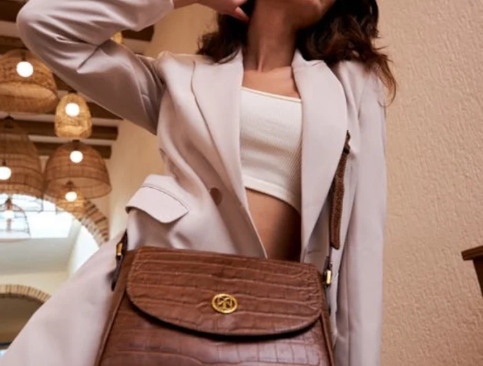 femme en tailleur beige au sac a main en cuir marron