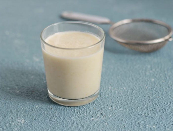 lait de pepin de melon comment faire un verre avec du lait vegetal sur un fond blue