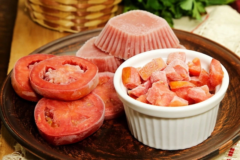 peut on congeler des tomates fraîches tomates rouges en rondelle et coupee dans un bol sur un plateau en bois