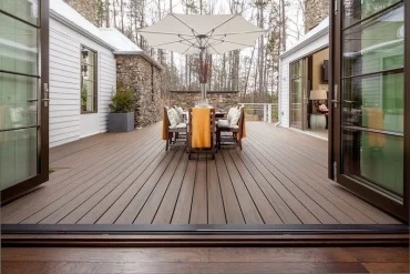 terrasse en bois dans une maison avec des tables et chaises