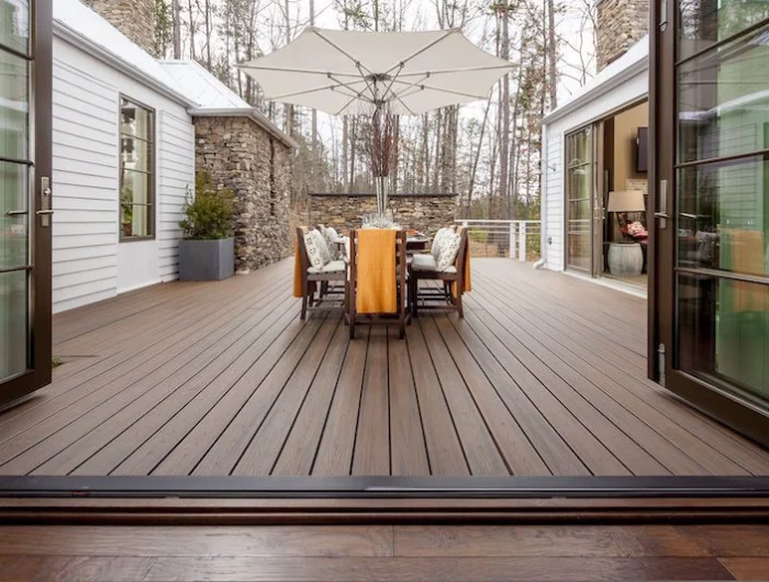 terrasse en bois dans une maison avec des tables et chaises