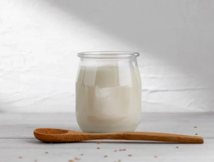 un yaourt naturel blanc avec une cuilliere en bois
