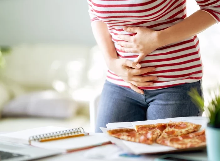 une femme qui a trop mange et tient son ventre