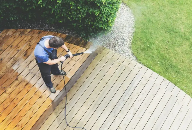 comment nettoyer une terrasse en ciment verdie un homme rince sa terrasse