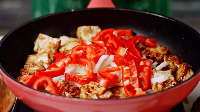 Add onion and red pepper to make tofu and vegetable recipe