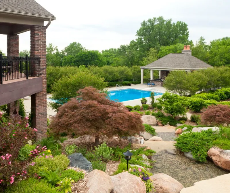 amenagement paysager autour d une piscine creusée rocaille fleurie avec arbustes jardin sec
