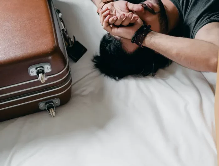 comment bien faire sa valise un homme fatigue etale sur son lit