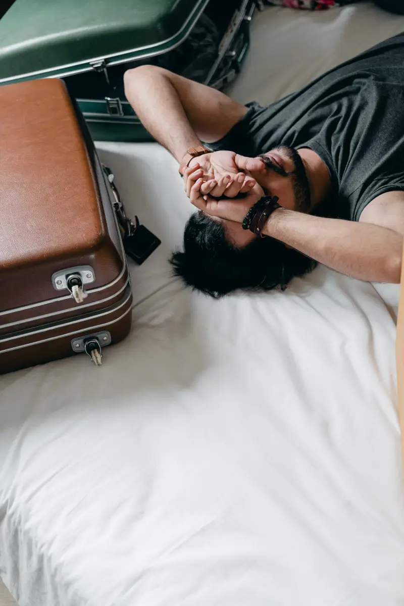 comment bien faire sa valise un homme fatigue etale sur son lit