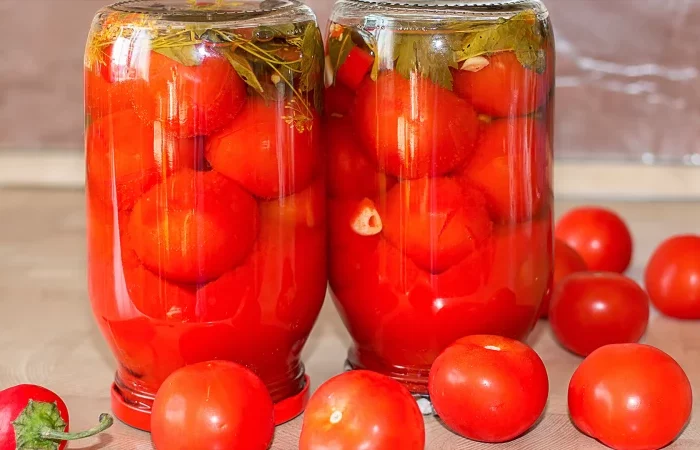 deux bocaux en verre avec des tomates la tete en bas