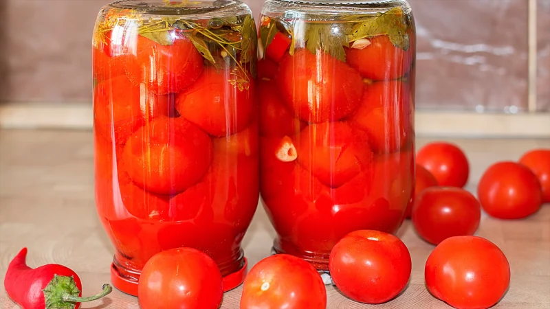 deux bocaux en verre avec des tomates la tete en bas