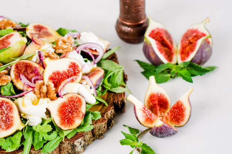 halved figs salad wooden board