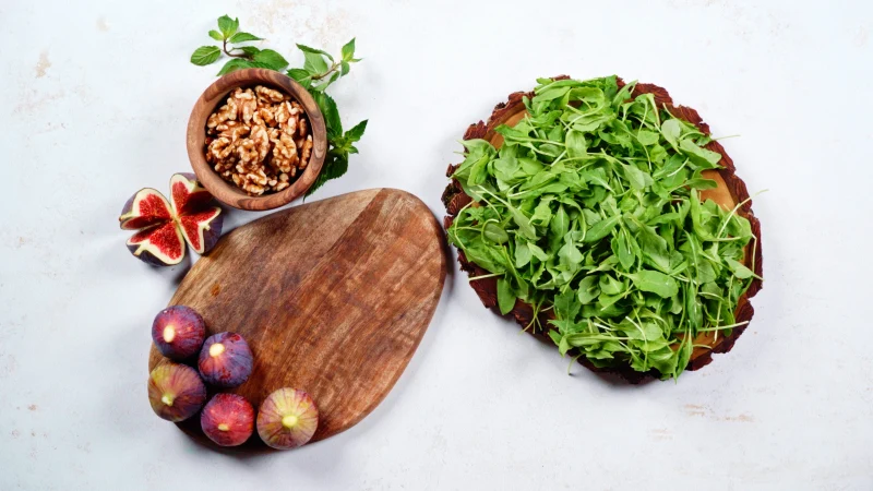 green salad figs walnuts wooden table