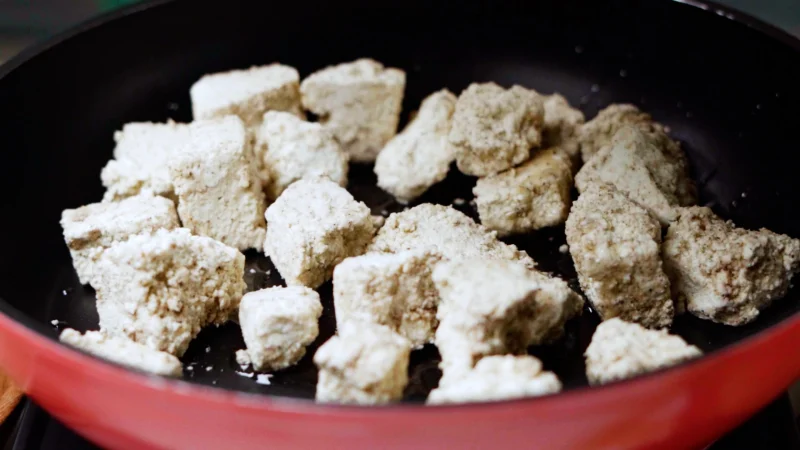 Fry tofu in sesame oil on a stove, a quick and easy recipe for vegetarian tofu