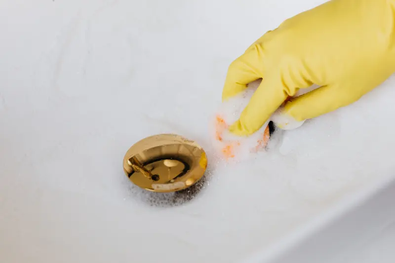 gants de nettoyage jaunes lavabo bouchon dore eau savoneuse