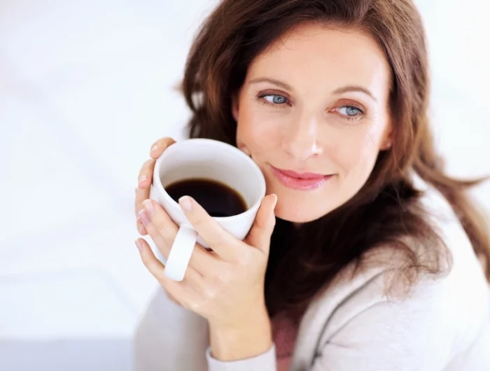 perdre du poids durablement après 50 ans femme aux yeux verts boit du cafe