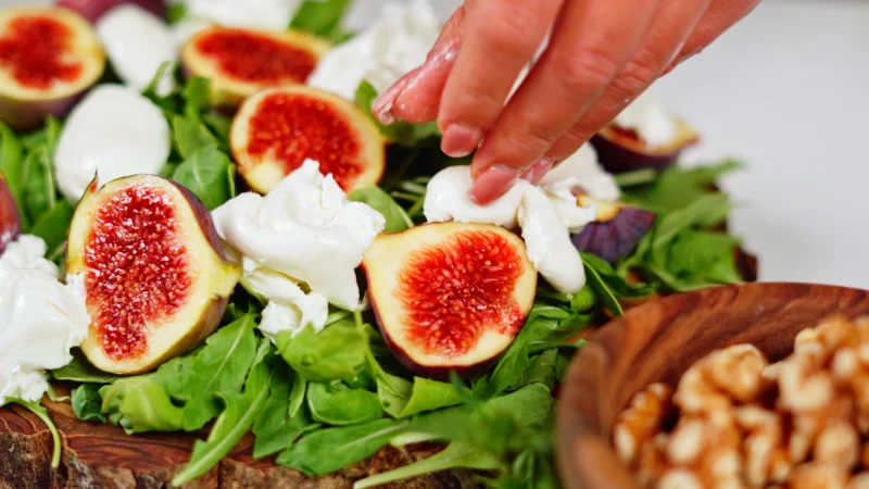 green salad white cheese nuts hand figs
