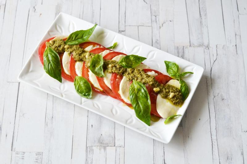 salads summer dish prepare a salad with cheese, tomatoes and pesto in a rectangular plate