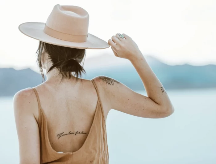 tatouage sur dos citation femme capeline art corporel symboles