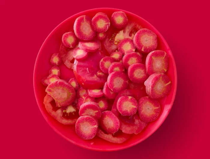 une assiete rouge sur fond rouge avec des fruits rouges