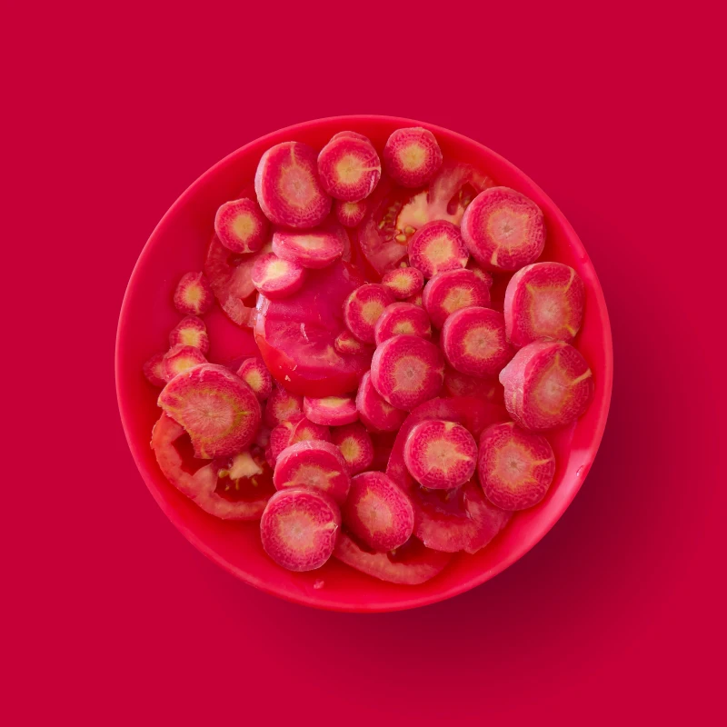 une assiete rouge sur fond rouge avec des fruits rouges
