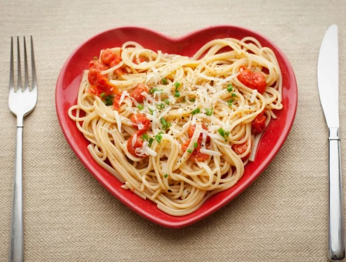 une assiette rouge avec des spagetti couteau et fourchette