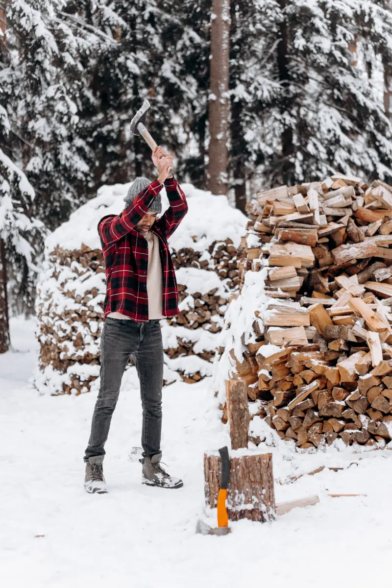 quels sont les mauvais bois de chauffage un homme qui fend du bois en hiver