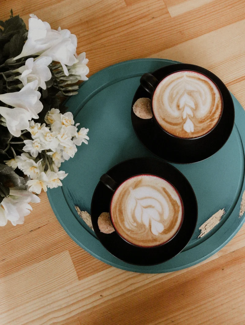 deux tasses de cafe table fleurs blanches