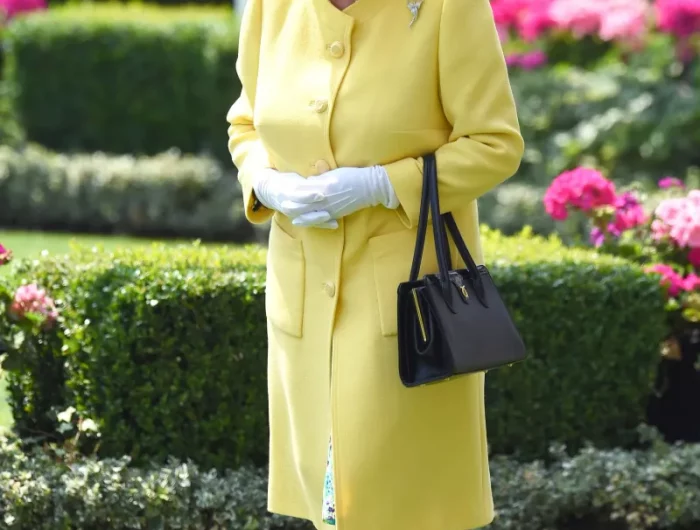 manteau long jaune queen elizabeth chapeau plumes sac a main noir