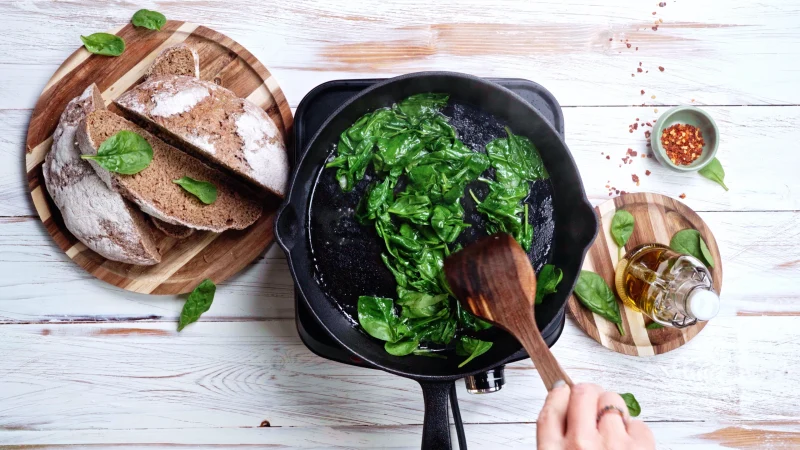 skillet spinach wooden spoon bread olive oil