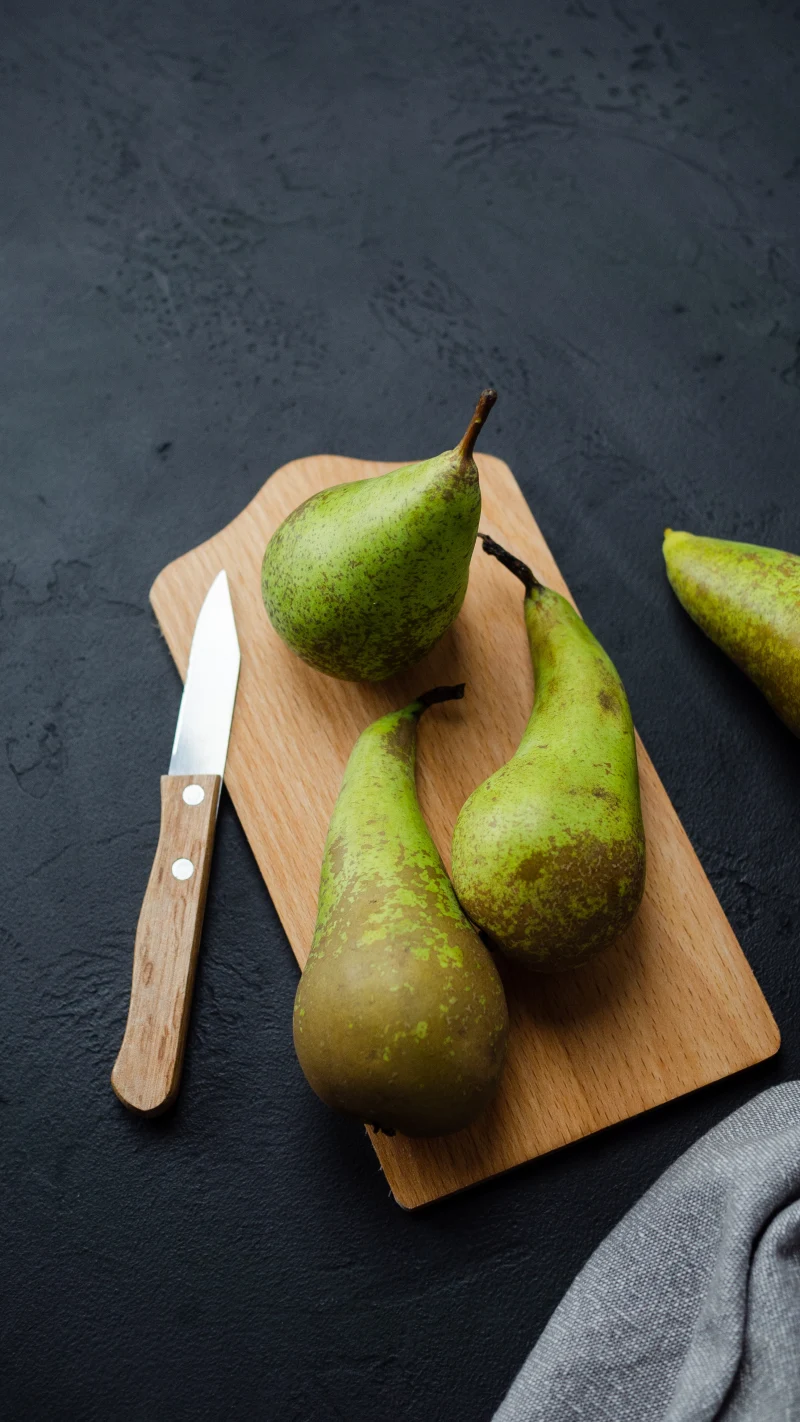 pears on a wooden board knife