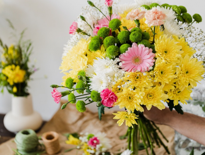 preparation de bouquet de fleurs jaunes et roses ciceaux et fils