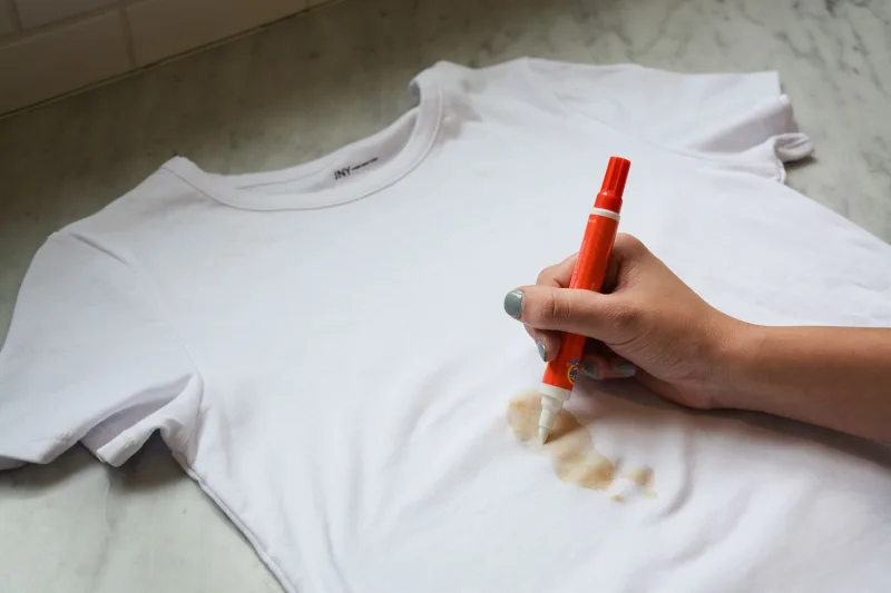 utilisation de stylo detacheur pour nettoyer une tache sur un tee shirt blanc
