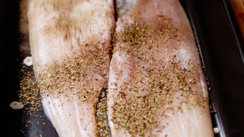 Season fish fillets with dried oregano