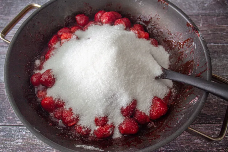 preparation de fruits rouges et de sucre blanche pour la cuisson de confiture dans une casserole
