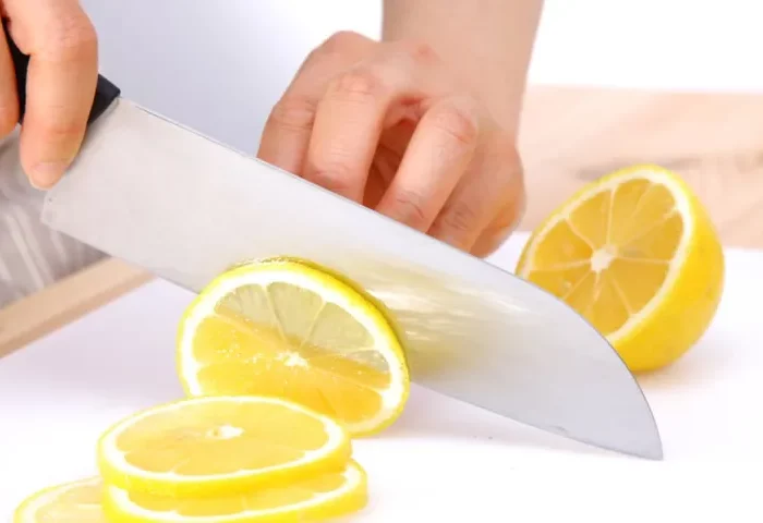 citron decoupe en tranches fines avec un couteau large