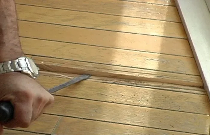 comment enlever moisissure bois une main souleve une planche en bois