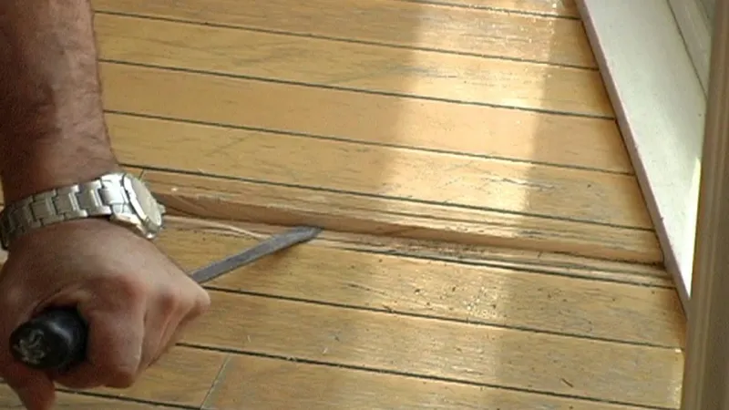 comment enlever moisissure bois une main souleve une planche en bois