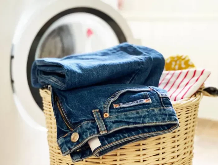 jeans plie dans un panier traisse devant un lave linge
