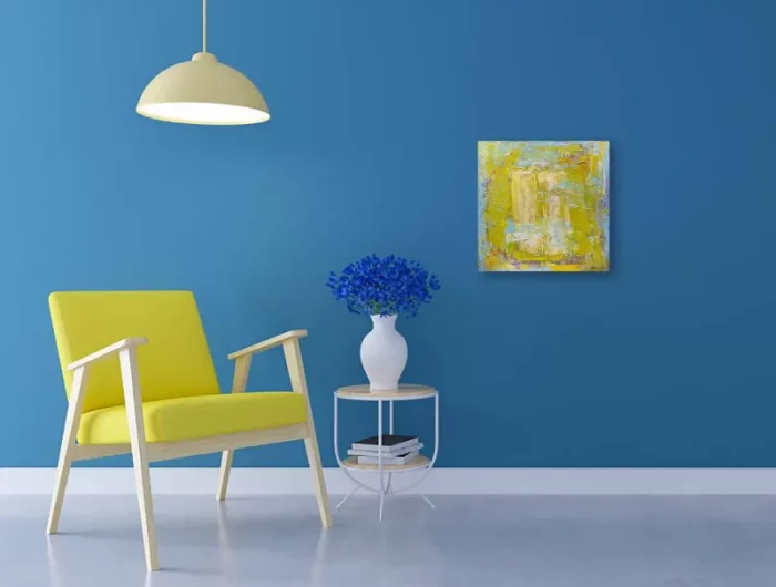 mur peint en bleu dans une ambiance froide avec un fauteuil jaune