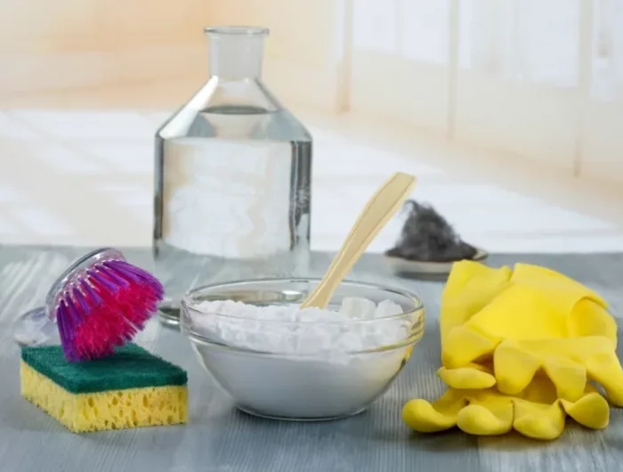 nettoyer de la moisissure avec du bicarbonate de soude coupe de bicarbonate gants jaunes et eponge sur unetable