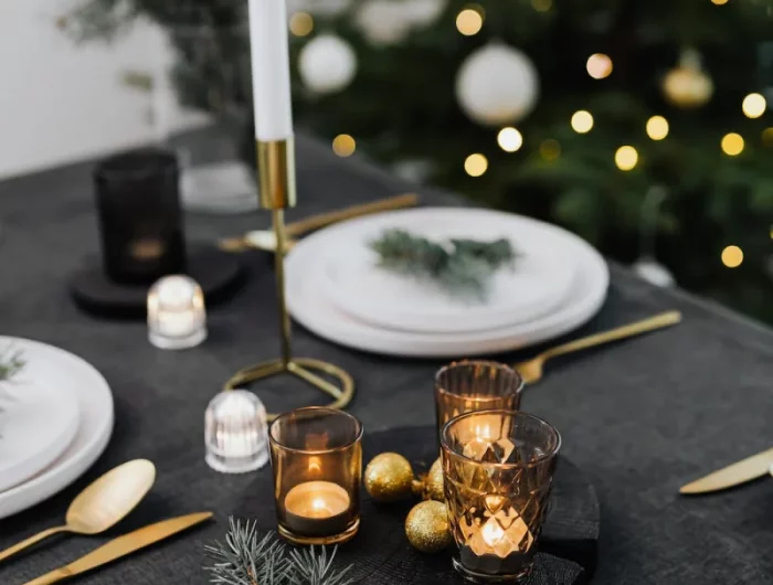 branches de pin boules de noel et bougeoirs sur nappe noire idees deco tables de noel interessantes