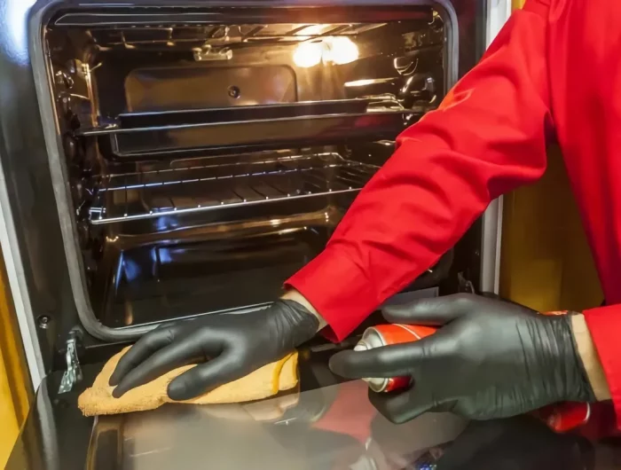 comment nettoyer un four très sale avec des produits naturels main en gant noir essuie porte