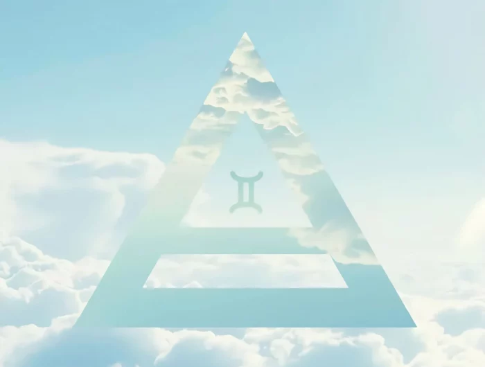 le symbole du signe astrologique des gemaux inscrit dans un triangle sur fond du ciel tres claire et des nuages étincelantes des blancheur